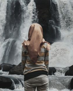 Rear view of woman against waterfall