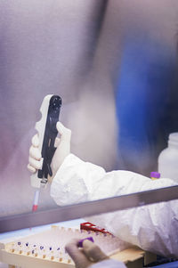Scientist pipetting sample into test tubes in laboratory  person