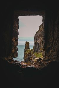 Rock formation in sea against sky