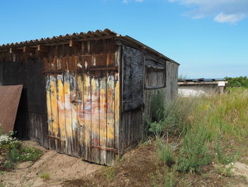 Abandoned house on field against sky