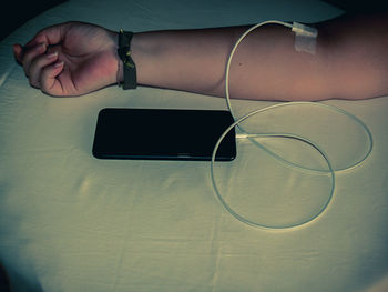 Midsection of person holding smart phone on table