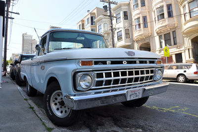 Vintage car on street by buildings in city