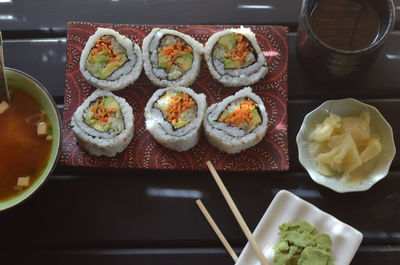 High angle view of sushi with sauces served on table