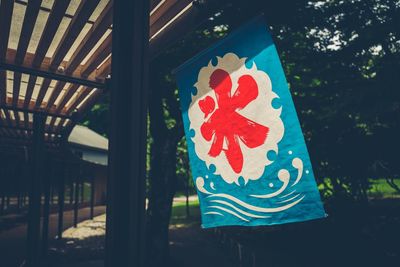 Close-up of multi colored umbrella against trees