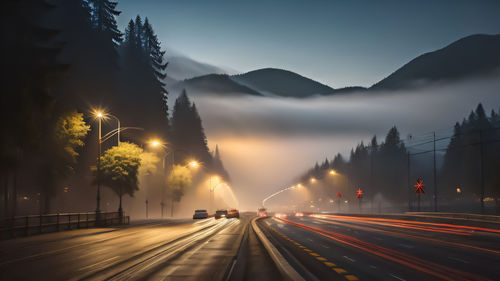 Light trails on road against sky during sunset