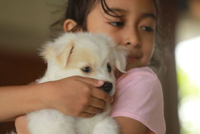 Close-up of girl holding dog