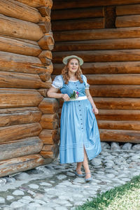 Full length of young woman standing against wall