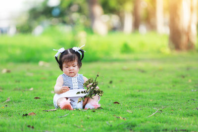 Cute boy sitting on field