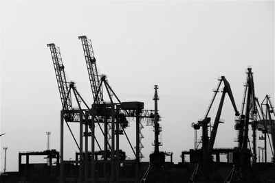 Cranes at construction site against sky