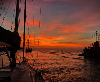 Sailboats sailing on sea against sky during sunset