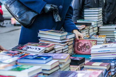 Cropped image of woman standing by bookstall