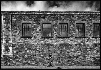 Full length of woman walking on old building