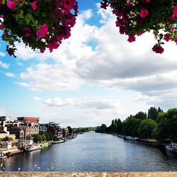 Scenic view of river against sky in city