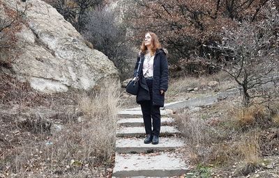 Full length of woman standing on rock