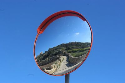 Close-up of basketball hoop against blue sky