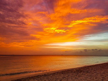 Scenic view of sea against dramatic sky during sunset