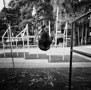 Rear view of woman swinging at playground