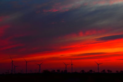 Scenic view of silhouette field against orange sky