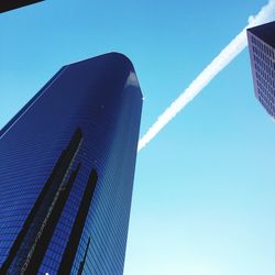 Low angle view of skyscrapers against clear blue sky
