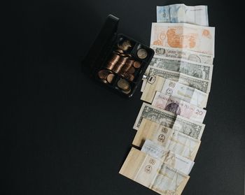 High angle view of coins on table against black background