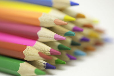 Close-up of colored pencils over white background