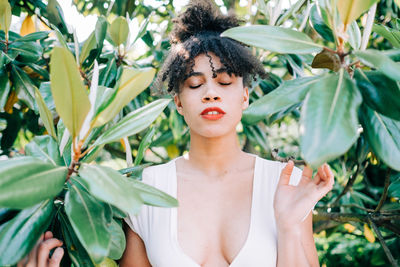 Close-up of teenage girl with eyes closed amidst plants