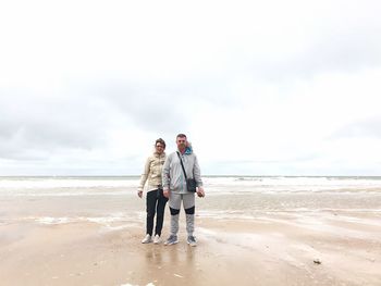 Men on beach against sky