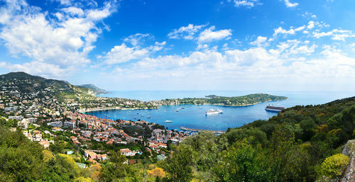 Aerial view of city by sea against sky