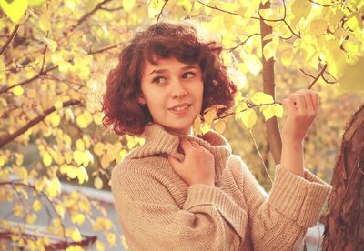 Portrait of smiling young woman holding plant