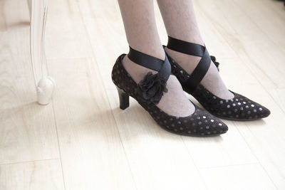 Low section of woman standing on hardwood floor