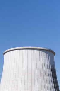 Low angle view of silo against clear blue sky
