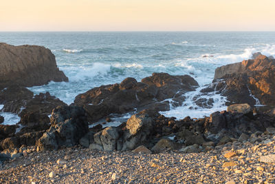 Rocks on beach against sky