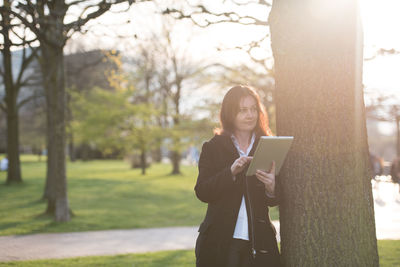 Young woman using mobile phone in park