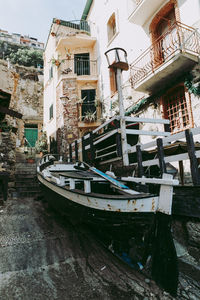 Boats moored in canal by old buildings in city