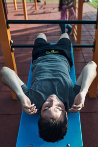 Young man doing sit-ups during his workout in a modern calisthenics street workout