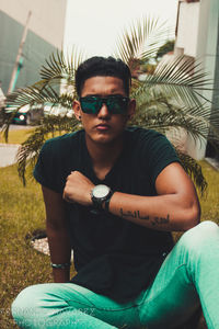 Portrait of young man sitting in sunglasses