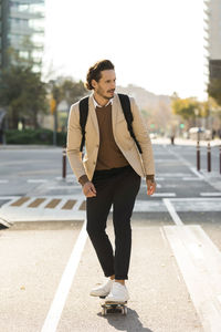 Man with backpack skateboarding in the city