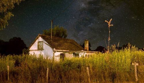 House on field against sky at night