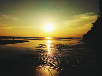 Scenic view of sea against dramatic sky during sunset