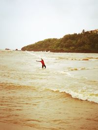 Man surfing in sea against clear sky