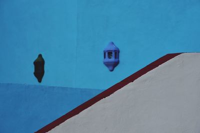 Low angle view of lamp on wall against building