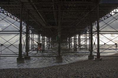 Silhouette bridge on beach against sky