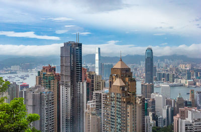 Buildings in city against cloudy sky