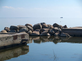 Rocks by sea against sky