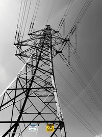 Low angle view of electricity pylon against sky