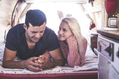 Couple holding hands while lying down on bed