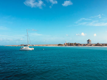 Sailboats in sea against blue sky