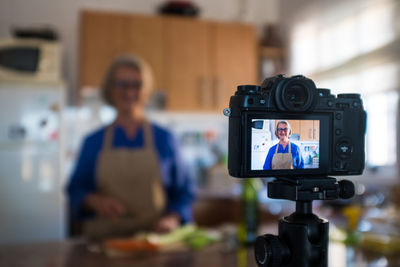 Close-up of camera filming woman at home