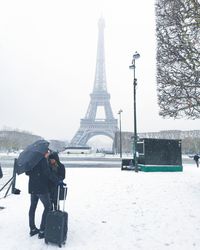 Full length of man on snow covered tower in city