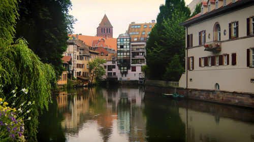 River by buildings in city against sky